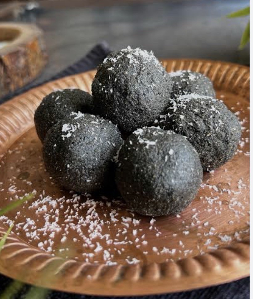 A plate of black seed glow balls with dates, nuts and black seeds