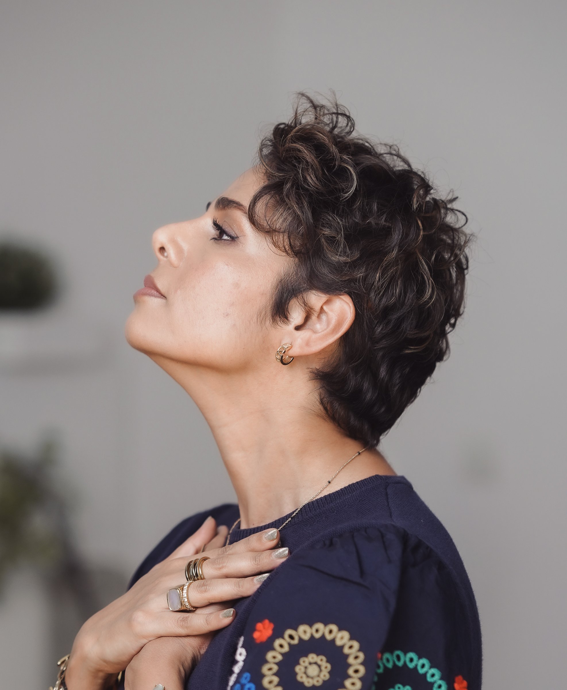 In profile, palms resting below the collarbone as the jaw begins its slow work