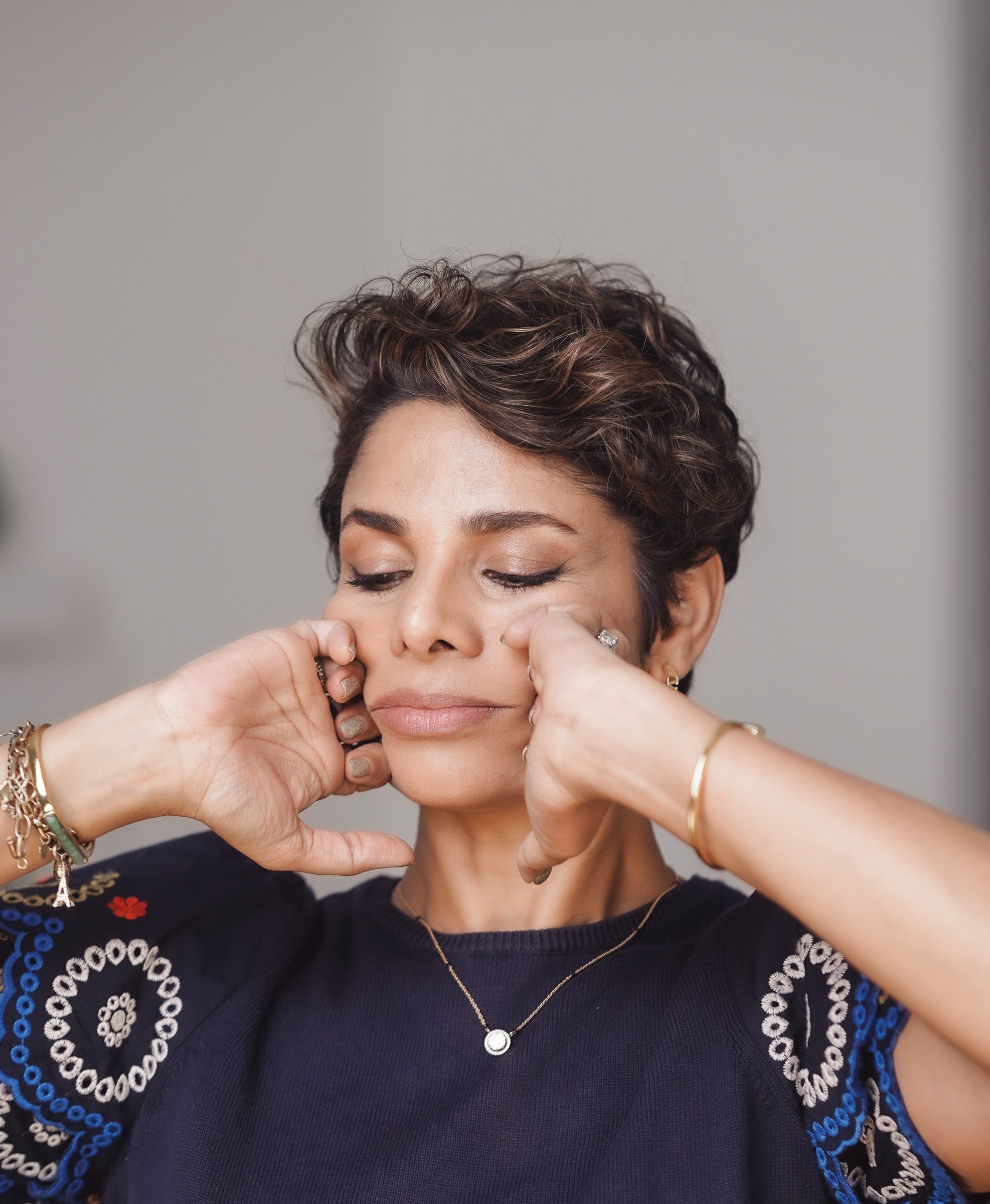 Knuckles sculpting upward from the nasolabial folds toward the cheekbones