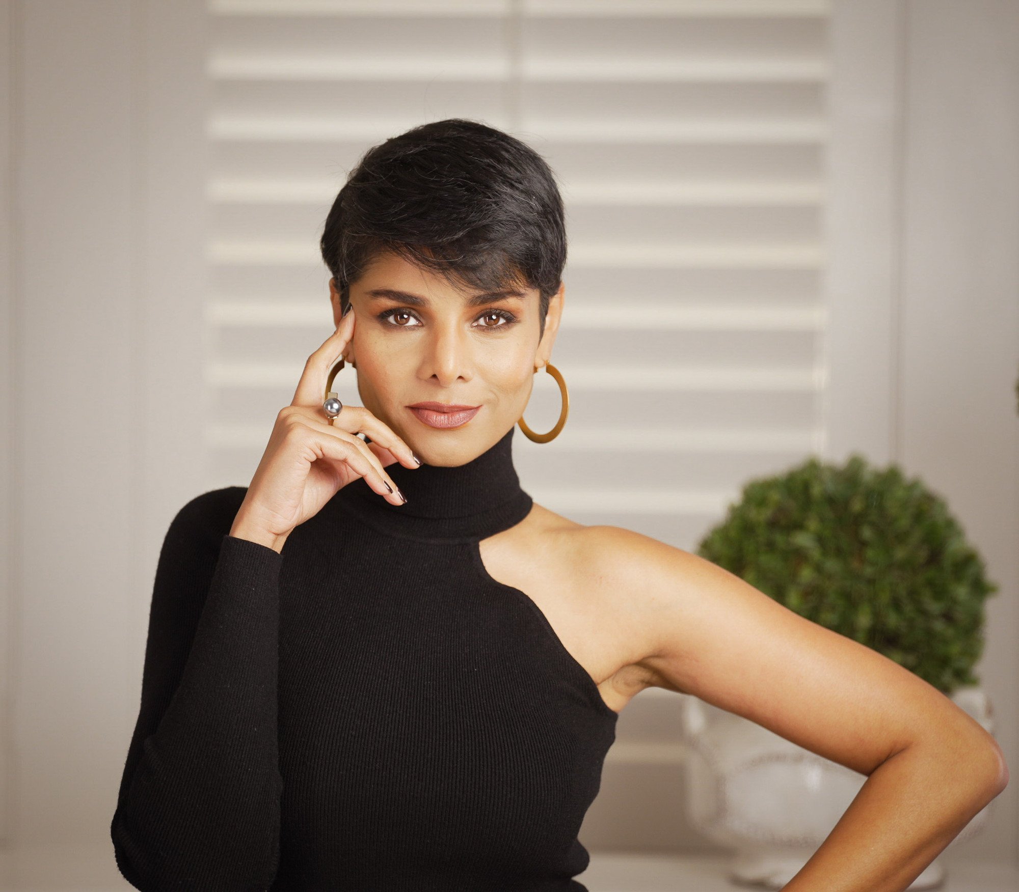 Parmita Katkar in a black turtleneck, hand resting against her temple